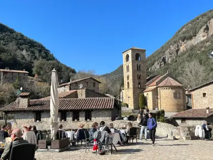 Café tables in the square beside a Romanesque church and its tower
