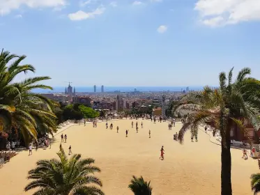 La plaza abierta con palmeras y la ciudad extendiéndose hasta el mar