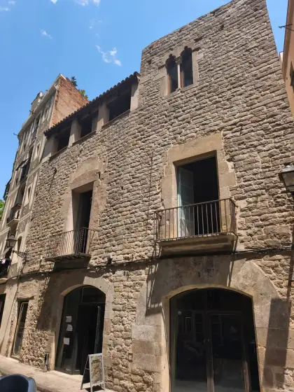 Una casa medieval de piedra del recorrido, con balcones de hierro y arcos