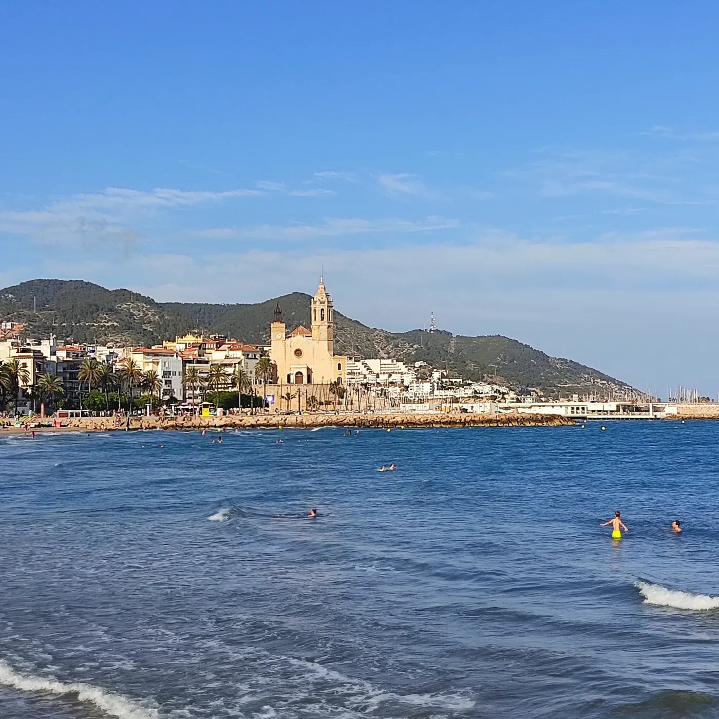La playa de Sitges con la iglesia de Sant Bartomeu sobre el promontorio