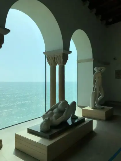 La galeria d’arcs sobre el mar del museu Maricel, amb una escultura davant l’aigua